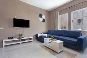 a living room with a blue couch and a tv at La Casa Bianco in El Cotillo
