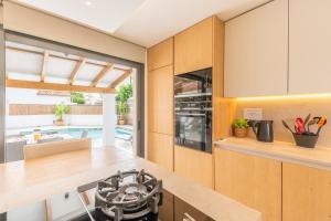 a kitchen with wooden cabinets and a counter top at Villa Ana Puerto Pollensa in El Port
