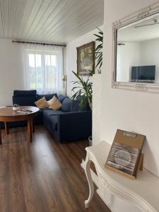 a living room with a blue couch and a table at Ferienwohnung Modelshauser Mühle in Hinterbuch