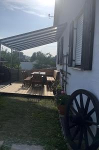 a wooden deck with a table and chairs on a house at Ferienwohnung Modelshauser Mühle in Hinterbuch