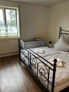 a bedroom with a bed with white sheets and a window at Ferienwohnung Modelshauser Mühle in Hinterbuch