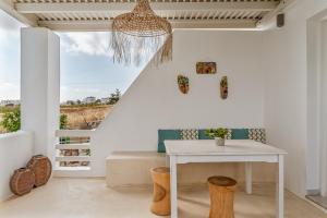 a white room with a table and a window at Aeolos Thalia Suite in Agkidia