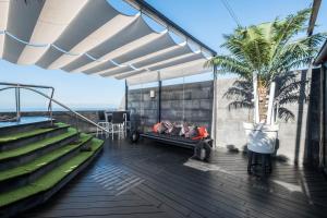 a balcony with a couch and a palm tree at Spr Ático in Santa Úrsula