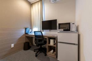 a room with a desk with a computer and a chair at HOTEL R9 The Yard Minamiarupusu in Shimo-iino