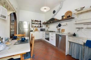 a large kitchen with white appliances and a table at Casa Marcone in Moneglia