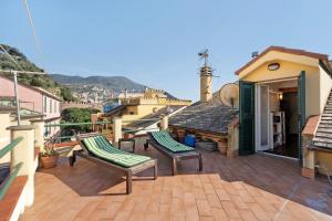 a balcony with two chairs and a house at Casa Marcone in Moneglia