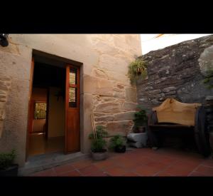 a stone building with a door and some plants at O Lar de Natalio in Rianjo +10 photos