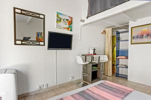 a bedroom with a bed and a tv on the wall at Appartement Pinède Romane Fréjus in Fréjus +14 photos