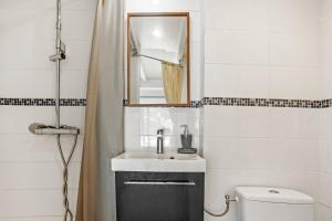 a bathroom with a sink and a mirror and a toilet at Appartement Pinède Romane Fréjus in Fréjus