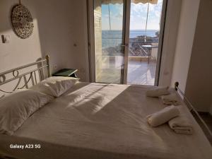 a bedroom with a large bed with a large window at Menidi Sea View 302 in Menídion