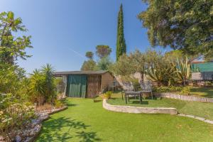 a garden with a table and chairs in a yard at Appartement Pinède Romane Fréjus in Fréjus
