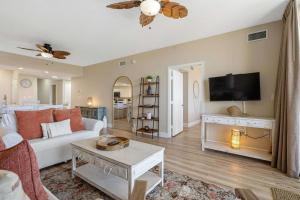 a living room with a white couch and a tv at Gulf Front condo with Beach access and shared Pool in Fort Walton Beach