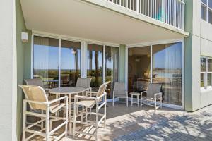 a patio with chairs and a table and some windows at Gulf Front condo with Beach access and shared Pool in Fort Walton Beach +33 photos
