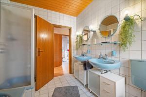 a bathroom with two sinks and two mirrors at Betty’s Home in Gersheim +39 photos
