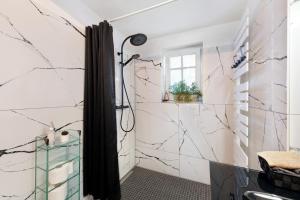 a bathroom with white marble walls and a shower at Elbparadies in Stade +21 photos