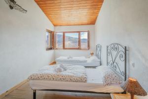 a bedroom with two beds and a window at Ecolgica Casa Del Sol 1 in Navacepeda de Tormes