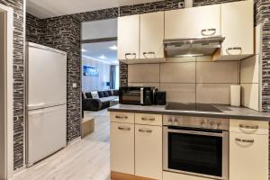 a kitchen with white cabinets and a refrigerator at Studioapartment am Hafen in Flensburg