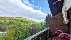 a balcony with two chairs and a view of a mountain at Fewo Jörges in Obernhausen