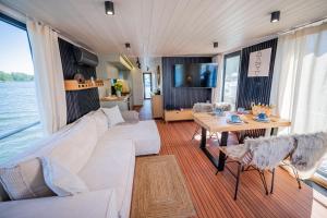 a living room with a white couch and a table at Wohlfühl-Hausboot Elements Woma D13 in Fürstenberg