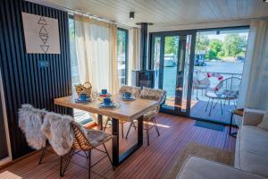 a dining room with a table and chairs and a porch at Wohlfühl-Hausboot Elements Woma D13 in Fürstenberg