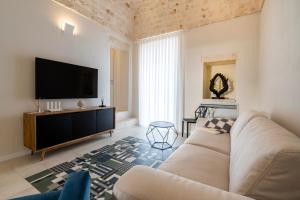 a living room with a couch and a flat screen tv at Civico40 Suite in Locorotondo