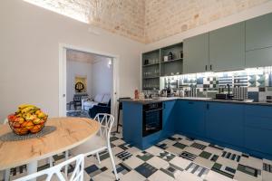 a kitchen with blue cabinets and a table with a bowl of fruit at Civico40 Suite in Locorotondo