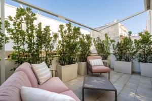 a balcony with a couch and chairs and potted plants at Civico40 Suite in Locorotondo
