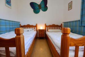 two beds in a room with a butterfly clock on the wall at Haus Titisee in Löffingen