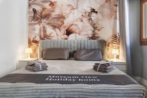 a bedroom with a large bed with a tropical wallpaper at Museum View, vista sul museo in Sassello