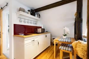 a kitchen with white cabinets and a wooden table at Stub'n Rettl in Waischenfeld