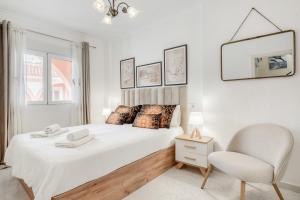 a white bedroom with a bed and a chair at Verano Azul in La Mata +12 photos