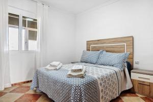 a bedroom with a bed with two towels on it at Apartamento Faro de Barbate in Barbate