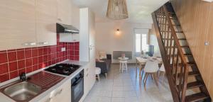 a kitchen with a staircase leading to a living room at Escapade Pirouaise - la Salicorne in Pirou