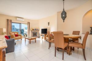 a living room with a dining room table and a couch at Norah’s House in Carvoeiro