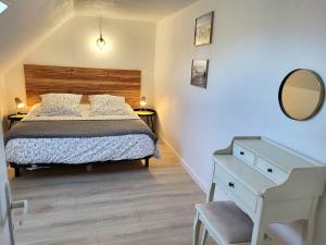 a bedroom with a bed and a dresser and a mirror at Escapade Pirouaise - la Salicorne in Pirou