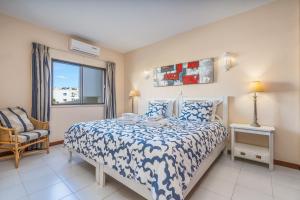 a bedroom with a bed and a chair and a window at Norah’s House in Carvoeiro +28 photos