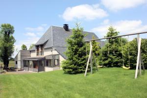 a house with a yard with a swing at Gîte De La Poucinière in Saint-Sauves- dʼAuvergne