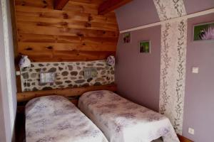 a bedroom with two beds in a room with wooden walls at Gîte De La Poucinière in Saint-Sauves- dʼAuvergne +11 photos