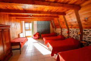 a room with four beds in a room with wooden walls at Gîte De La Poucinière in Saint-Sauves- dʼAuvergne