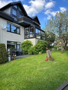 a house with a tree stump in the yard at Birkenhauer inkl Meine Card plus in Willingen