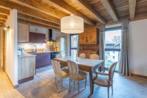 a kitchen and dining room with a wooden table and chairs at Charlotte la Marmotte in Morillon +12 photos
