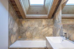 a bathroom with a tub and a sink at Charlotte la Marmotte in Morillon