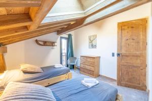 two beds in a bedroom with wooden ceilings at Charlotte la Marmotte in Morillon