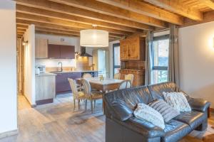 a living room with a leather couch and a table at Charlotte la Marmotte in Morillon