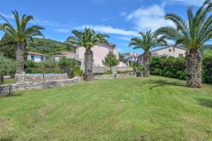 a large yard with palm trees and houses at Appartamenti Dolores in Campo nell'Elba