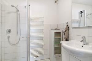 a white bathroom with a shower and a sink at Ferienwohnung Honberg in Tuttlingen +12 photos