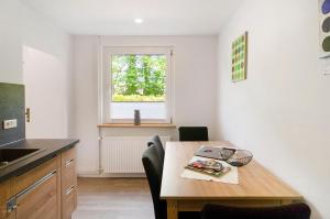 a kitchen with a wooden table and a window at Smolly's Ferienwohnung in Bad Zwischenahn