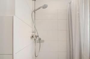 a shower with a shower head in a bathroom at Smolly's Ferienwohnung in Bad Zwischenahn +17 photos