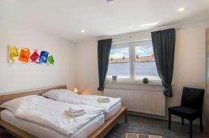 a bedroom with a bed and a window and a chair at Smolly's Ferienwohnung in Bad Zwischenahn