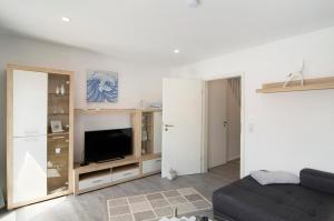 a living room with a couch and a tv at Smolly's Ferienwohnung in Bad Zwischenahn